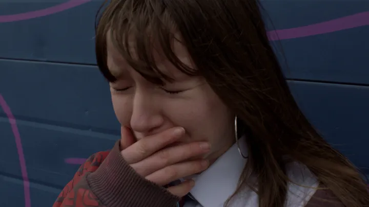 Still from Skive — hand over mouth
