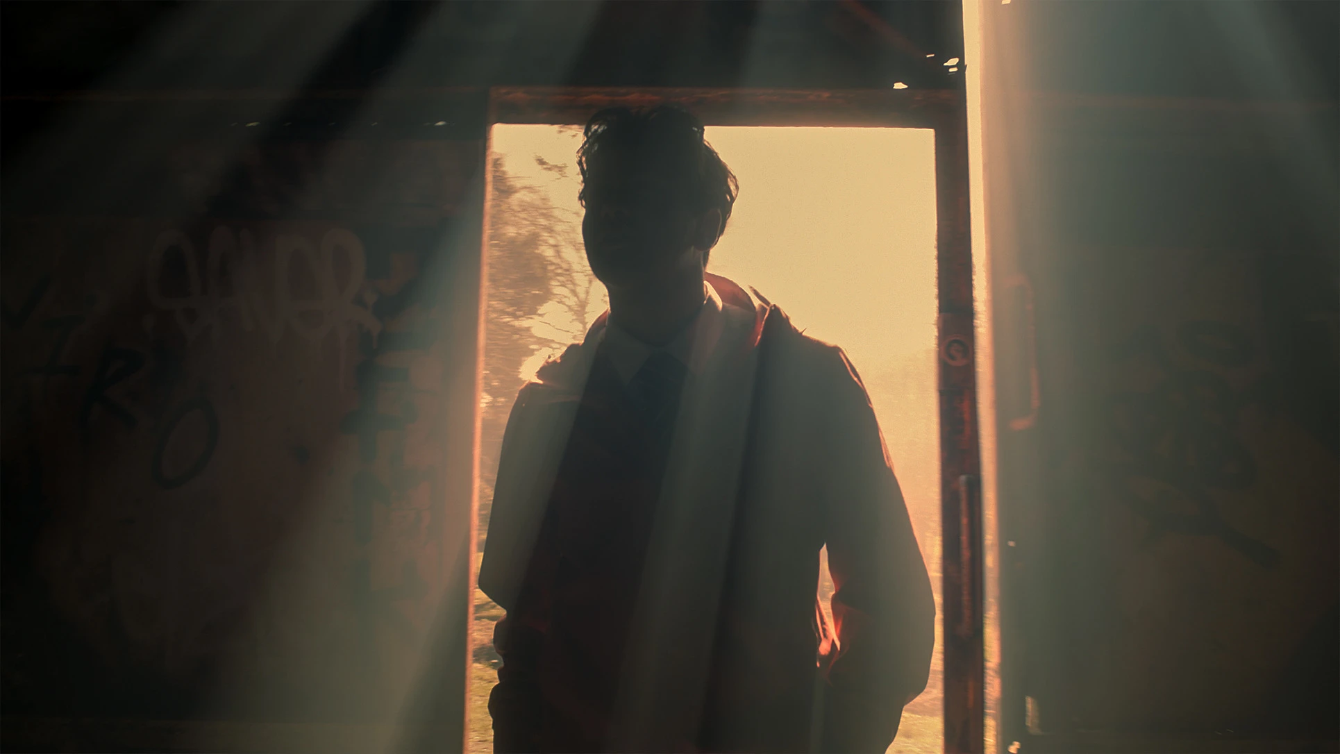 Nathan silhouetted in a sunlit doorway